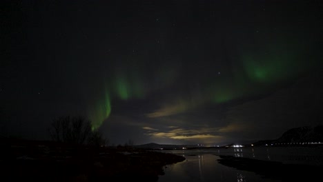 Green-Aurora-Borealis-in-motion-at-dark-sky-after-sunset-on-lake-in-Iceland,-static-time-lapse