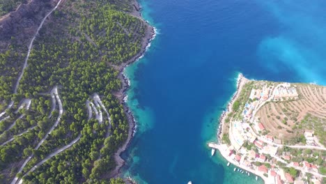 Tilting-drone-shot-revealing-the-rest-of-the-peninsula-Agriosiko,-a-secret-beach-getaway-in-the-island-of-Kefalonia-in-Western-Greece