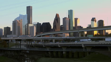 Reveal-shot-of-downtown-Houston,-Texas-and-cars-on-I-45-North-freeway