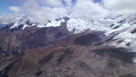 Paisaje-De-La-Región-Montañosa-De-Annapurna-En-Manang-Nepal,-Nieve-Derritiéndose-Debido-Al-Calentamiento-Global,-Nubes-De-Clima-Soleado,-Disparo-De-Drones-4k