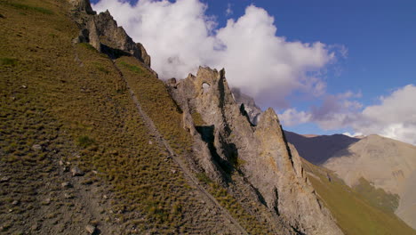 Sendero-De-Trekking-Hacia-El-Lago-Tilicho-Más-Alto-Del-Mundo-En-Manang-Nepal,-Estructura-única-Y-Extraña-En-Colinas-Con-Algas-Bajo-Las-Nubes-Cubiertas-De-Cielo-Azul-Con-Drones-Disparados-4k