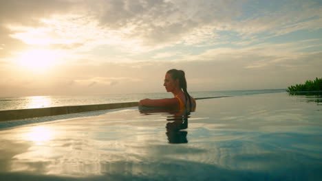 Einsames-Brünettes-Mädchen-Am-Pool-Und-Genießt-Den-Wunderschönen-Tropischen-Sonnenuntergang-Am-Meer