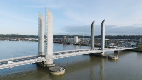 Jacques-Chaban-Delmas-bridge-with-vehicle-traffic-over-the-Garonne-River-in-Bordeaux-France,-Aerial-orbit-side-view