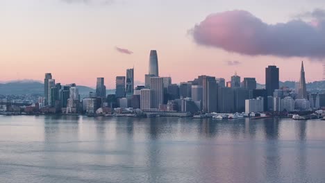 Aerial-pull-back-of-San-Francisco-skyline-and-Bay-Bridge-at-dawn