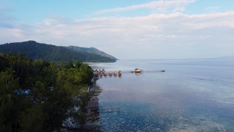 Malerische-Luftaufnahme-über-Häusern-Und-Hütten-Am-Wasser-Mit-Blick-Auf-Das-Meer-Auf-Einer-Tropischen-Insel-In-Raja-Ampat,-West-Papua,-Indonesien