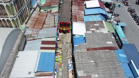 Eine-Drohne,-Die-Einem-Zug-Folgt-Und-über-Den-Mae-Klong-Eisenbahnmarkt-Schießt