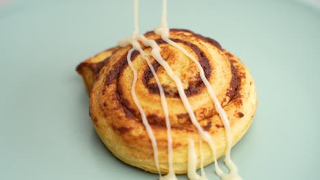 Cinnamon-bun-pastry-being-drizzled-with-icing