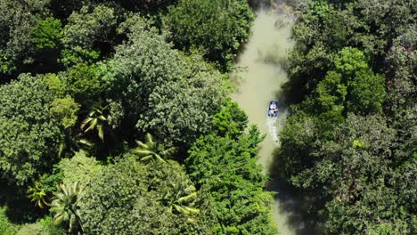 Aerial-Panoramic-Drone-Above-water-channel-through-the-dense-jungle-of-Guatemala-with-a-Sailboat