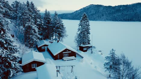 Cabaña-Noruega-En-La-Montaña-Con-Pinos-Junto-Al-Lago-Congelado-En-Invierno
