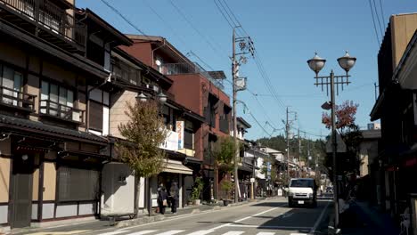 Escena-Con-Peatones-Y-Automóviles-A-Lo-Largo-De-La-Carretera-Cerca-Del-Casco-Antiguo-De-Takayama-En-Japón.