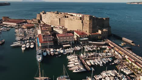 Drone-orbiting-around-a-fort-located-on-a-sea-coast-in-Italy,-Naples