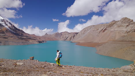 Las-Turistas-Recorren-El-Lago-De-Mayor-Altitud-Del-Mundo-En-La-Región-Montañosa-De-Annapurna-En-Nepal,-Disfrutando-De-Caminar-Junto-Al-Lago,-El-Clima-Soleado-Y-Una-Vista-Increíble-Tomada-Con-Drones-4k