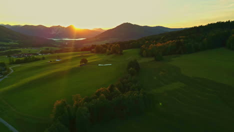 Aerial-view-of-Austria's-landscape-at-sunset-with-golden-light-over-fields-and-mountains