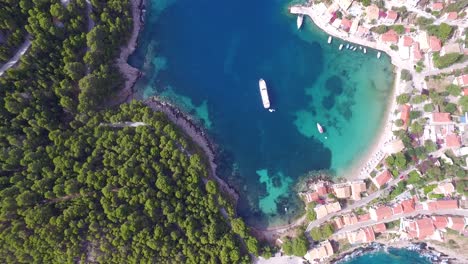 Retreating-overhead-drone-shot-of-a-secret-beach-getaway-known-to-a-few-people-as-Agriosiko-Beach,-located-in-the-island-of-Cephalonia,-situated-in-Western-Greece