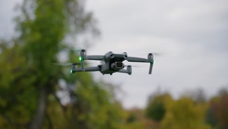 Orbitalaufnahme-Einer-Dji-Drohne,-Die-In-Der-Luft-Fliegt,-Mit-Bäumen-Im-Hintergrund