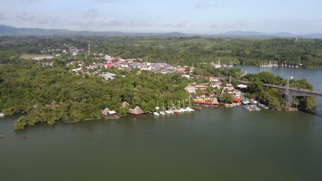 Brücke-über-Den-Fluss-Rio-Dulce-In-Guatemala-Mit-Der-Küste-Des-Río-Dulce-Und-Dem-Städtischen-Dock