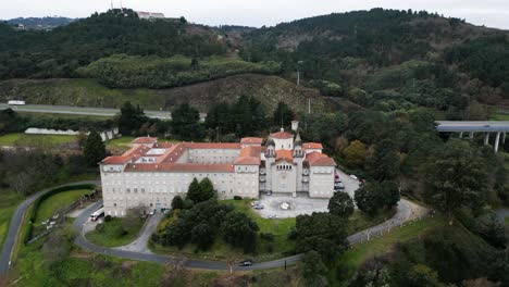 High-angle-aerial-orbit-around-windowed-walls-of-Catholic-seminary-religious-school-in-Ourense