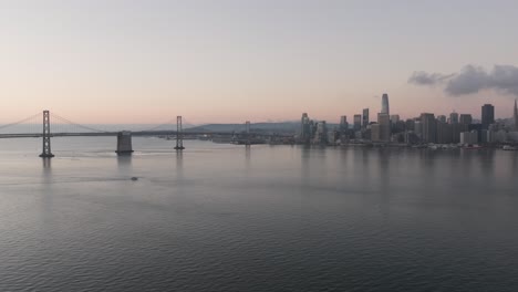 Dawn-aerial-pullback-expansive-view-of-San-Francisco-Skyline-and-Oakland-Bay-Bridge