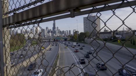 Dolly-in-shot-through-chain-link-fence-to-the-busy-Eisenhower-Expressway-and-Chicago-skyline