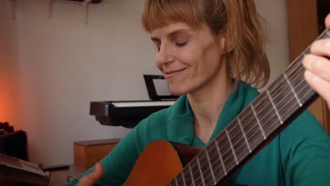 Inspired-Latin-woman-with-Guitar-is-singing-a-song-at-home