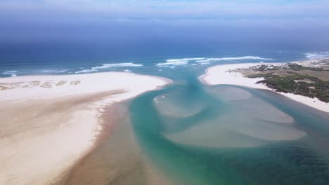 Lagoon-estuary-open-to-the-ocean-at-the-river-mouth-with-beautiful-sand-sediment-formation-visible-from-above