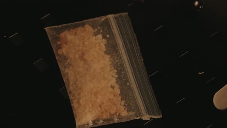 Transparent-bag-full-of-MDMA-on-a-black-table