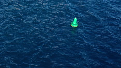 Green-buoy-rocks-in-deep-blue-Caribbean-ocean-water