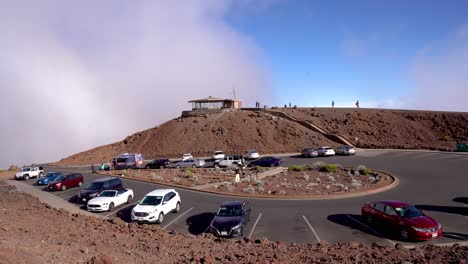 The-top-of-Haleakala-National-Park-in-Maui,-Hawaii,-Haleakala-visitor-center-pictured-above-the-clouds-before-sunset