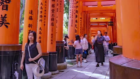 Time-lapse-of-people-Tourists-walking-through-the-Famous-Fushimi-Inari-Torii-Gates-Shrine,-Kyoto,-Japan-View-1-TILT