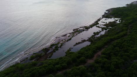 Se-Forman-Piscinas-Naturales-De-Marea-Durante-La-Marea-Baja-Mientras-La-Luz-Del-Atardecer-Brilla-En-Las-Tranquilas-Aguas-Del-Océano,-Piscadera-Curacao