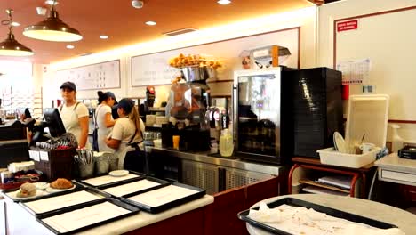 Lebhaftes-Café-Mit-Mehreren-Kellnerinnen,-Die-Den-Frühstücksservice-Leiten