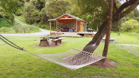 A-hammock-between-trees-in-front-of-a-wood-cabin-in-nature-in-New-Zealand