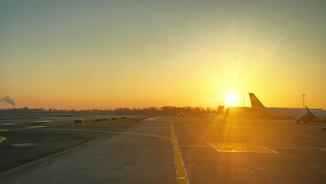 Escena-Del-Aeropuerto,-Vista-Por-Los-Pilotos,-En-El-Aeropuerto-De-Bolonia,-Italia,-Al-Amanecer-En-Un-Frío-Día-De-Invierno-Con-Un-Espectacular-Cielo-Naranja