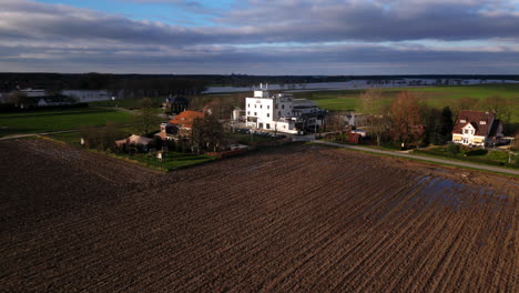 White-Hertog-Jan-beer-brewery-in-sunlight-in-the-middle-of-swampy-clay-fields-drone