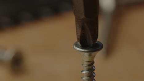 Macro-view-of-electric-screwdriver-drilling-out-metal-screw-in-slow-motion