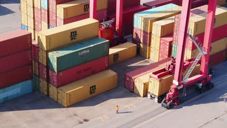 Large,-colorful-shipping-containers-stacked-in-busy-port-waiting-to-be-loaded-or-just-unloaded-from-cargo-ship