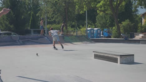 Stunt-scooter-rider-perform-180-degree-tail-whip-spin-from-skatepark-ledge