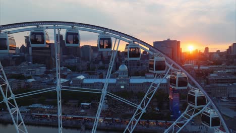 Drone-view-of-giant-wheel-attraction-in-Montreal,-Canada-at-sunset