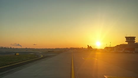 Airport-scene-while-taxing-for-departure-from-Bollogna-irport,-Itali,-shot-at-sunrise,-as-seen-by-the-pilots