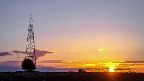 Time-lapse-of-a-vibrant-sunrise-sky-with-clouds-behind-a-radio-tower---copy-space