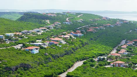 Rows-of-luxury-condos-look-out-over-tropical-ocean-in-lush-green-hillside-in-the-morning