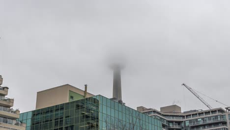 Time-lapse-zoom-out-of-dark-grey-clouds-in-motion-covering-famous-CN-Tower-in-Toronto-City