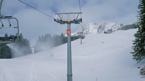 Chair-lifts-and-ice-flyers-moving-up-and-down-the-snowy-mountainside-of-a-skiing-destination-located-at-Engelberg,-in-Brunni,-Switzerland