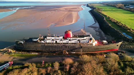 Ghost-Ship-the-Duke-of-Lancaster-at-sunset---drone-anti-clockwise-rotate,-bay-backdrop---Mostyn,-North-Wales,-UK