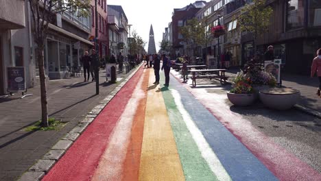 Straße-In-Reykjavik-In-Regenbogenfarben-Bemalt-Mit-Der-Lutherischen-Kirche-Hallgrimskirkja-Im-Hintergrund-In-Island-–-Weitwinkelaufnahme