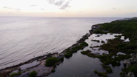 Aerial-dolly-above-natural-salt-pools-on-coastline-of-Piscadera-Curacao