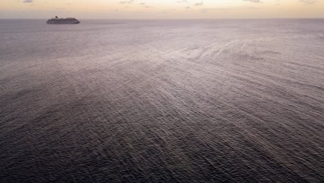 Sunlight-glistens-on-Caribbean-ocean-to-reveal-cruise-ship-on-horizon-at-sunset