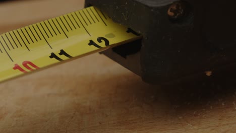 Macro-shot-of-yellow-measuring-tape-extending-in-slow-motion