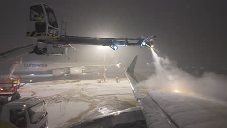 Aircraft-Wing-De-icing-On-A-Winter-Night-In-Munich-Airport,-Germany