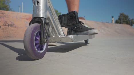 Close-up-of-stunt-scooter-rubber-wheel-and-action-camera-mounted-on-deck